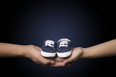 Çift mavi bebek patiği holding