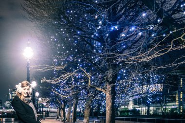 Kız ağaca christimas ışıkları ile yakın