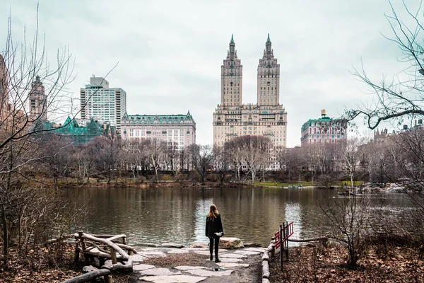 Fille près des arbres, de la rivière et des bâtiments au Central Park à Manh — Photo