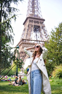 Yaz günü Paris, Fransa 'da Eyfel Kulesi' nin yanında duran şık bir turist kadın.