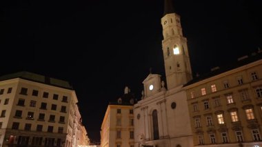 Viyana 'daki Michaelerplatz ve St. Michael Kilisesi' nin aydınlatılmış gece manzarası