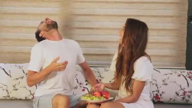 Mutlu çift meyveyi paylaşıyor ve evde gülüyor.