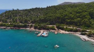 Açık mavi suya demirlemiş küçük teknelerin insansız hava aracı görüntüsü