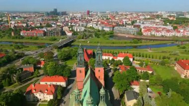 Poznan Katedrali 'nin turkuaz kuleleri, Katedral Adası' ndaki kırmızı çatıları, Ostrow Tumski 'nin çevresi Warta Nehri köprüsü ve güneşli yaz gününde modern şehir manzarasıyla çevrili.