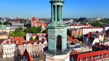 Poznan belediye binasının yeşil bakır kulesi kırmızı çatıların ve eski şehir merkezindeki tarihi binaların üzerinde yükseliyor.