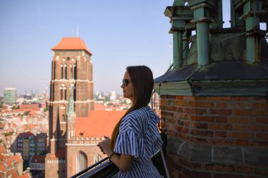 St. Mary Bazilika Kulesi ve Gdansk çatıları ile gözlem terasında bir bayan gezgin.