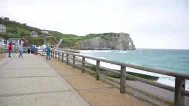 19 Nisan 2024 'te insanlar sadece Etretat kayalıkları ve sert deniz kullanımı manzaralı deniz gezisi boyunca yürür.