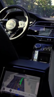 Otonom Waymo Jaguar I Pace 'in arka koltuğundan dikey iç görünüş. Arka yolcu dokunmatik ekranını ve Beverly Hills' teki boş sürücü koltuğunu gösteriyor.