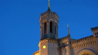 Alacakaranlıkta Lyon 'da ışıklı ve boyalı camlı kilise kulesi