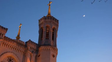 Lyon 'daki tarihi kilise kulesi, alacakaranlıkta mavi gökyüzü arka planıyla.