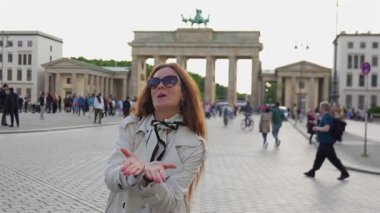 Kadın, 24 Mayıs 2025 'te Brandenburg Gate Berlin' de sadece editoryal kullanım için el kaldırıyor.