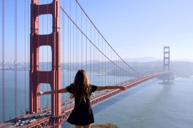 Genç bayan gezgin San Francisco köprüsünün keyfini çıkarıyor.