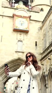 Bordeaux Fransa 'daki tarihi saat kulesinin altında selfie çeken bir kadın.