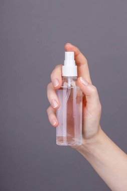 Sıvı dolu, kozmetik, dezenfektan ya da temizlik ürünü modelleme için ideal bir plastik sprey şişesini tutan elin yakın çekimi..