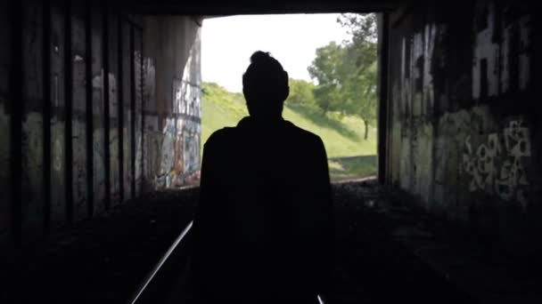Killen går in i en tunnel på järnvägsspåren — Stockvideo