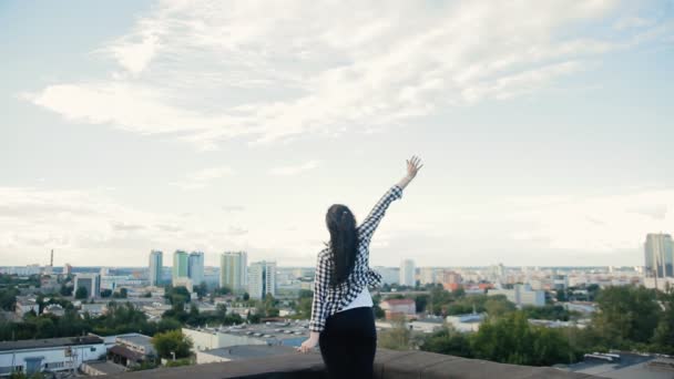 Menina coloca as mãos para os lados e no telhado goza de vida — Vídeo de Stock