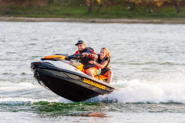 Krasnodar, Rusya - 25 Temmuz 2020: Güneşli yaz gününde arka koltukta neşeli bir kadınla jet ski şoförü