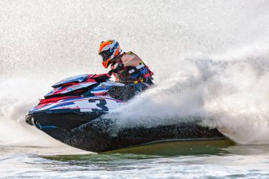 Krasnodar, Rusya - 25 Ekim 2020: Jet ski yarışçısı Güney Rusya Aquabike Şampiyonası 'nda yarışırken günbatımında su sıçrayan bir su aracını sürüyor.