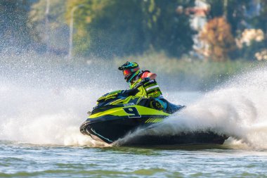 Krasnodar, Rusya - 25 Ekim 2020: Jet ski yarışçısı Güney Rusya Aquabike Şampiyonası 'nda yarışırken günbatımında su sıçrayan bir su aracını sürüyor.