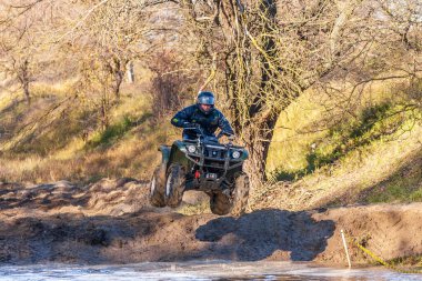 Afipsip, Rusya - 31 Ekim 2020 Çamur Yarışı 'nda bisikletli sporcu suya atladı. ATV motosiklet yarışmaları popüler bir ekstrem spor ve açık hava aktivitesidir.