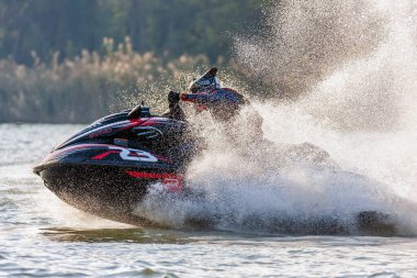 Krasnodar, Rusya - 24 Ekim 2020: Jet kayak yarışçısı Güney Rusya Aquabike Şampiyonası 'nda yarışırken su aracını dönüş ve sıçrama yaparak sürüyor.