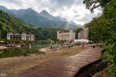 Soçi, Rusya - 30 Eylül 2020: Rosa Khutor dağ kayak merkezinin yeşil yaz Kafkaslar dağ ormanı ve Aibga tepeleri ile çevrili güzel manzaralı kasabası.