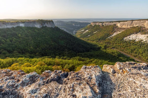 Ukrayna 'nın Kırım kentindeki antik bir mağara kasabası olan Mangup-Kale' nin tepesinden panoramik manzara - popüler turistik eğlence ve seyahat merkezi. Manzaralı gün batımı mavi gökyüzü manzarası