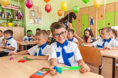 Krasnodar, Rusya - 1 Eylül 2020: İlkokul eğitimine başlama tatilinde okul sıralarında birinci sınıf öğrencileri. Birinci sınıftaki mutlu çocuklar.