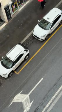 İtalya 'da iki taksi yan yana park edilmiştir. İnsanlar gün geçtikçe kaldırımda yürüyorlar. Etraflarında trafik akıyor..