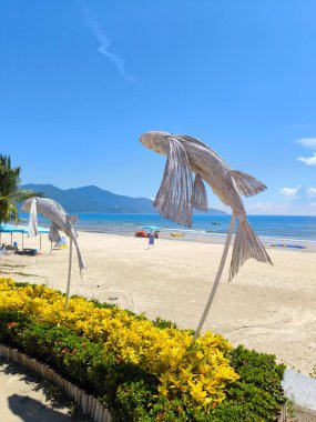 Tropikal bir plajda örülmüş balık heykelleri