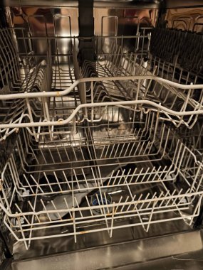 Üst ve alt rafları metal çatallarda pas lekeleri gösteren bulaşık makinesini aç