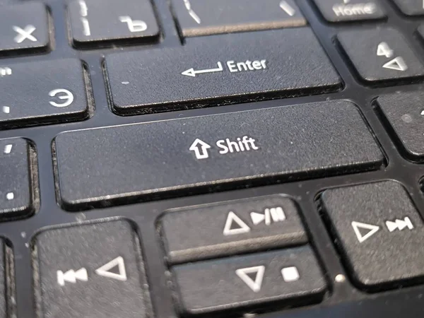 Yakın plan görüntüsü, bir bilgisayar klavyesinde siyah Shift ve Enter tuşlarının yanı sıra çalmak, duraklatmak, atlamak ve durdurmak için ortam kontrol düğmelerini vurgular
