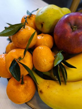 Renkli bir mandalina, muz, elma ve armut koleksiyonunu vurgulayan detaylı bir çekim.