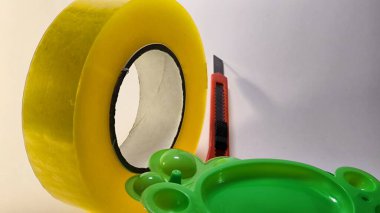 Kırmızı bıçak ve yeşil plastik nesnelere sarılı sarı şeritten bakarak yaratıcı yakın çekim