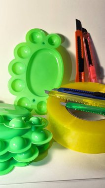 Kırmızı bıçak ve yeşil plastik nesnelere sarılı sarı şeritten bakarak yaratıcı yakın çekim