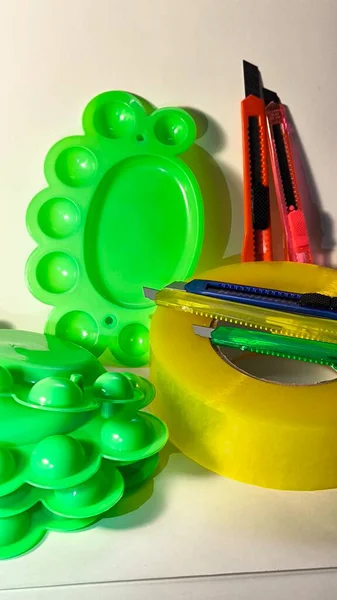 Kırmızı bıçak ve yeşil plastik nesnelere sarılı sarı şeritten bakarak yaratıcı yakın çekim