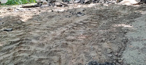 Toprak zemini, asfalt ve toprak yığınına giden ağır ekipman izleriyle kapatın. Yol yenileme ya da yıkım alanı sanayi manzarası