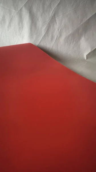 Kırmızı geometrik yüzey ve beyaz buruşuk kağıt doku arka planının soyut bileşimi