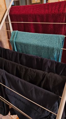 Çamaşır yıkama konsepti için çok renkli havlular ve giysiler iç tarafta asılı.