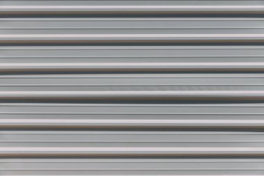 Şehir caddesinde çizgili açık renkli çitlerin yakın görüntüsü. İnşaat alanını çevreleyen çit. Yasak giriş. Çizgili duvar deseni