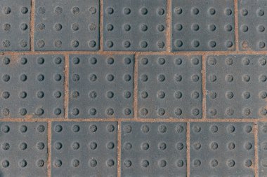 Gri duvar kare fayanslarının yakın görüntüsü halka açık asfalt yolundaki noktalı arkaplan. Eski taş ya da taşların yüzeyi ya da dokusu. Taş zemin. Ön kiremitlerin dokusu. Kare blok beton arkaplan.