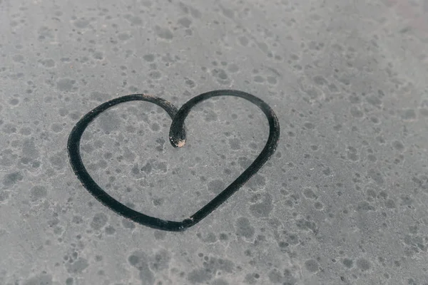 汚れた車の窓にハートシンボル 車のグレア側の窓に指で心臓を描いた 指で心を描いた バレンタインデーのロマンチックな絵 長い間洗浄されていない車 — ストック写真