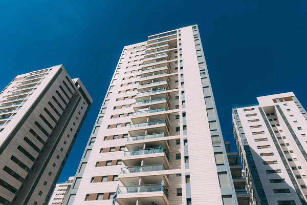 Aşağıdan yüksek bir bina ve bulutlu mavi bir gökyüzü. İsrail 'de yeni bir bina, aşağıdan vurulmuş. Yeni Rosh Haayin bölgesinde dokuz katlı bir bina. Modern bina. Yeni bir bina.