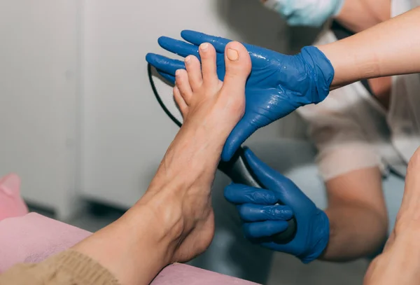 Kuaförde ayak pedikürü ameliyatı. Sertleştirilmiş deri rendesi. Spa 'da genç bir kadının bacağı. Topukluların soyulması. Profesyonel pedikür süreci. Güzellik ve sağlık anlayışı.