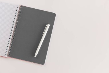 Spiral, gri sayfa ve beyaz kalemle defter açtı. Beyaz arkaplanda izole edilmiş metin için düz ve yerleşim yeri. Okula dönelim. Üst görünüm, boşluğu kopyala. Yüksek çözünürlük Öğrenci işyeri
