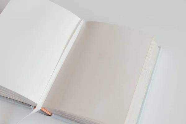 Yer imli beyaz arkaplan üzerine boş bir kitap aç. İçinde defter var. Kitabı kare biçiminde boşalt. Tasarım konsepti - beyaz defterin üstü boş görünümü