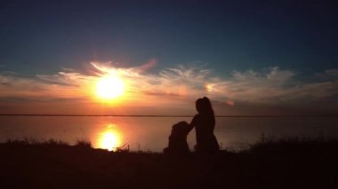 kadın köpeğini günbatımında hugs.