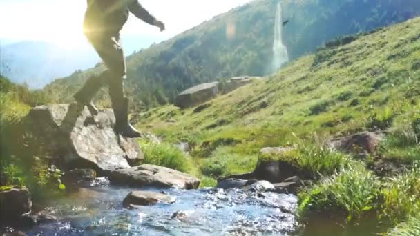 Hiker drinking water from mountain stream behind waterfollow — Stock Video