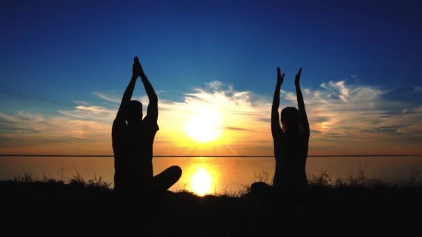 Pár sedí jógu na pláži při západu slunce — Stock video