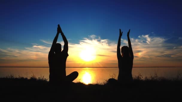 Couple assis yoga sur la plage pendant le coucher du soleil — Video